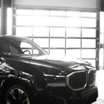 a black car parked in a garage next to a garage door